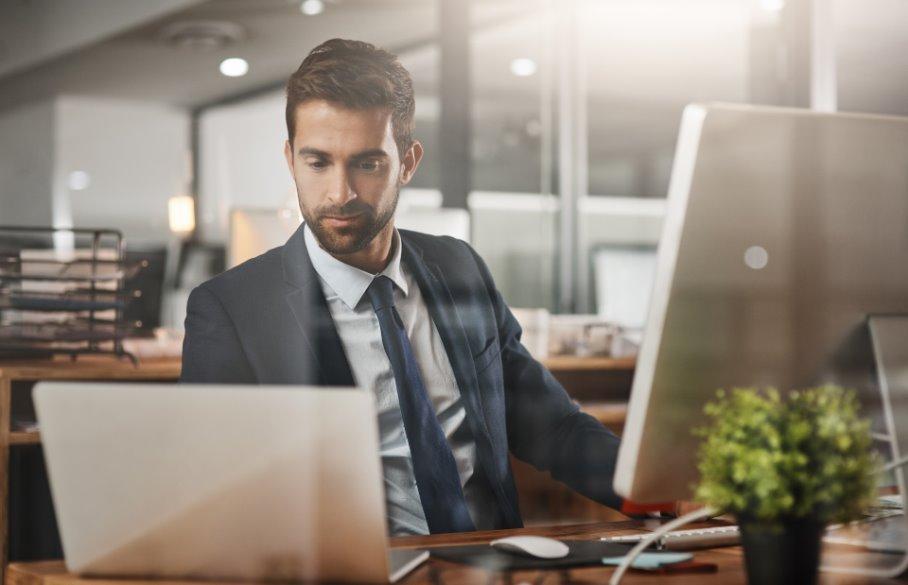 A person in a suit and tie looking at a computer